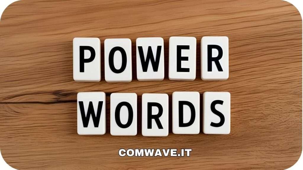 Blocchi di lettere bianche disposti per formare le parole "POWER WORDS" (Parole Potenti) su uno sfondo di legno con venature. In basso, il testo "COMWAVE.IT".